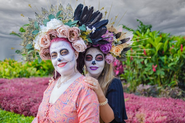 Mother and daughter made up as catrinas. Day of the dead and Halloween makeup. Outdoor portrait of two women.