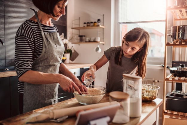 Mother and daughter making apple pie dough