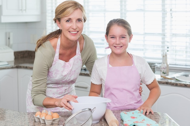 Photo mother and daughter making cake together