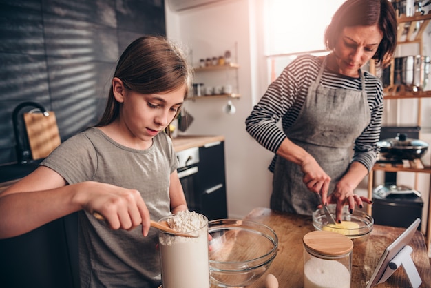 Madre e figlia che producono pasta per la torta di mele