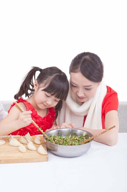 Mother and daughter making dumplings