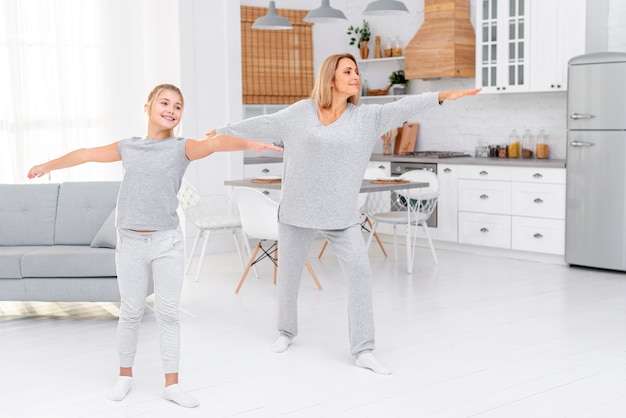 Photo mother and daughter making fitness exercises