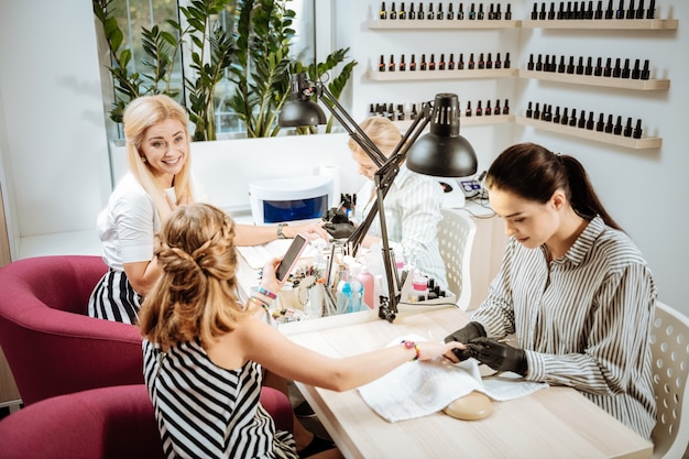 Madre e figlia. madre e figlia che indossano vestiti bianchi e neri che visitano il salone del manicure