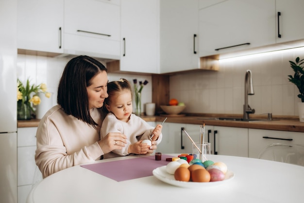 Mother and daughter paint easter eggs at home