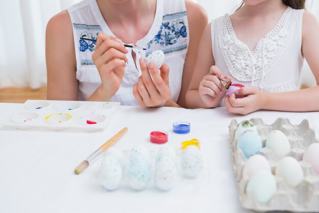 Mother and daughter painting easter eggs