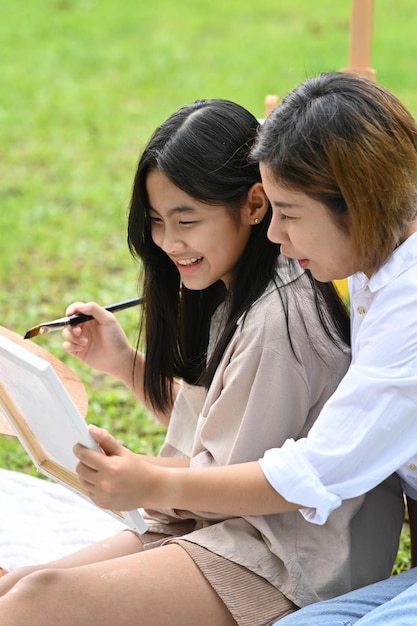 Mother and daughter painting together at the garden