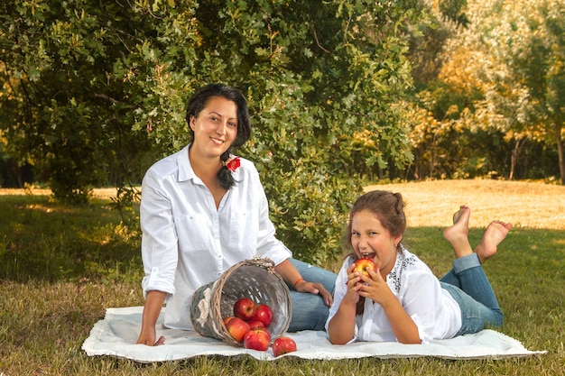 mother and daughter picnic in the park with apples