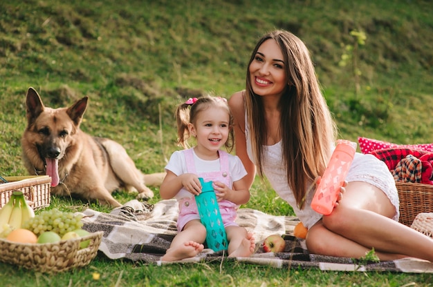 Foto madre e figlia a un picnic con un cane