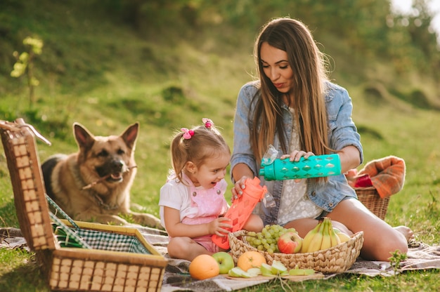 mother and daughter at a picnic with a dog