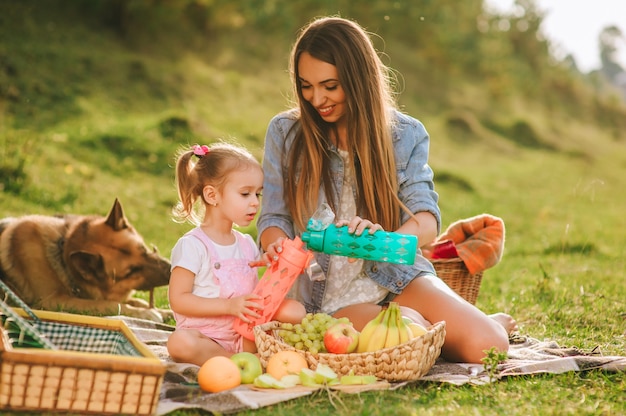 mother and daughter at a picnic with a dog