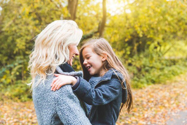 Mother and daughter playing and looking each other at park