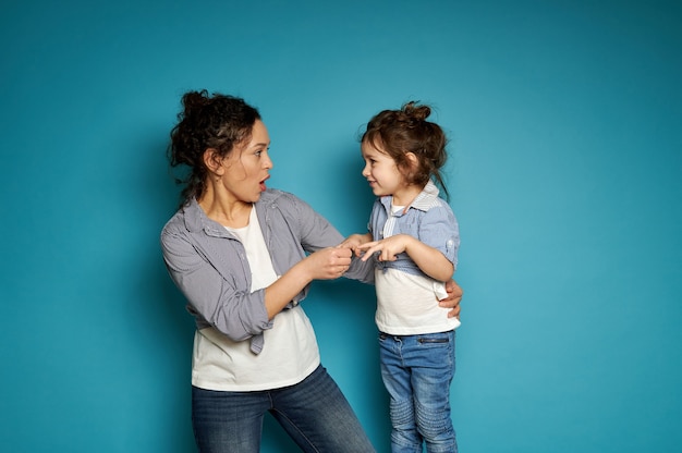 Mother and daughter playing a rock-paper-scissors game. Motherhood and childhood concept