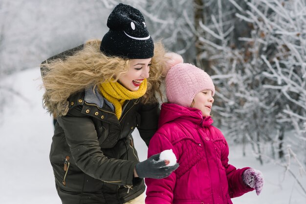 母と娘が雪で遊ぶ