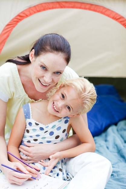 Photo mother and daughter playing in tent