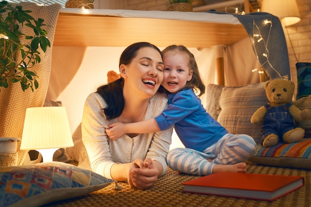 Mother and daughter playing in tent