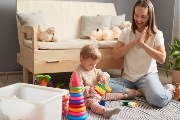 mother and daughter playing with colorful blocks on the floor of the living room at home activities with children inside early childhood development
