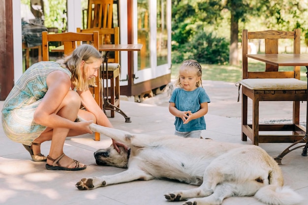 Foto madre e figlia che giocano con il cane sul pavimento