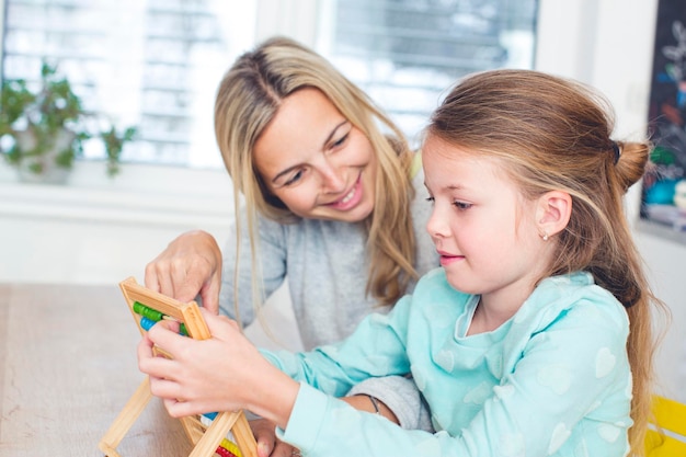 mother and daughter playing with toy at home