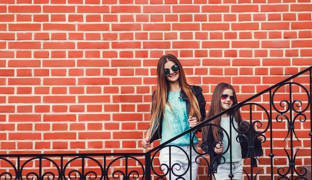 Mother and daughter posing in stylish clothes