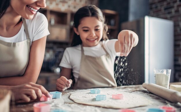 Mother and daughter preparing dough for cookies