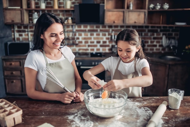 Mother and daughter preparing dough for cookies