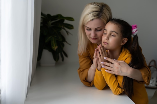 Foto madre e figlia che leggono la bibbia e pregano.