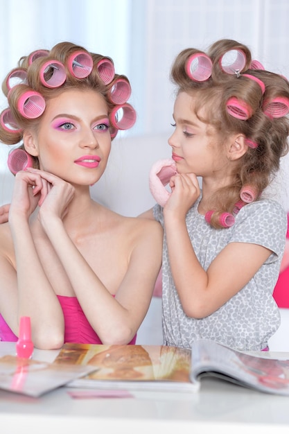 Photo mother and daughter reading magazine