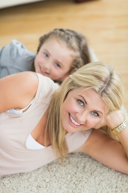 Mother and daughter resting on floor