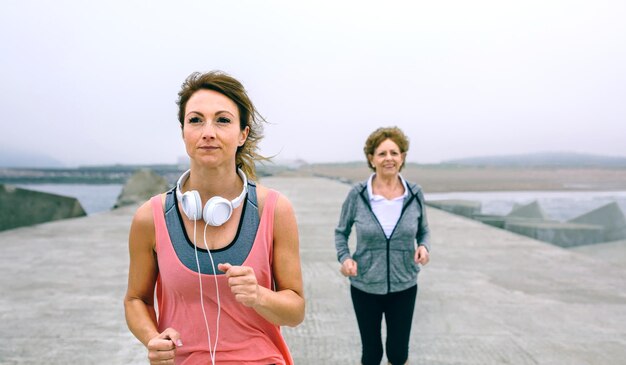 Mother and daughter running at beach