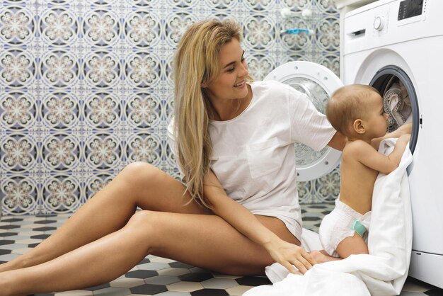 Photo mother and daughter sitting on bed at home