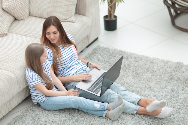 Mother and daughter sitting on the floor in a cozy living roomphoto with copy spac