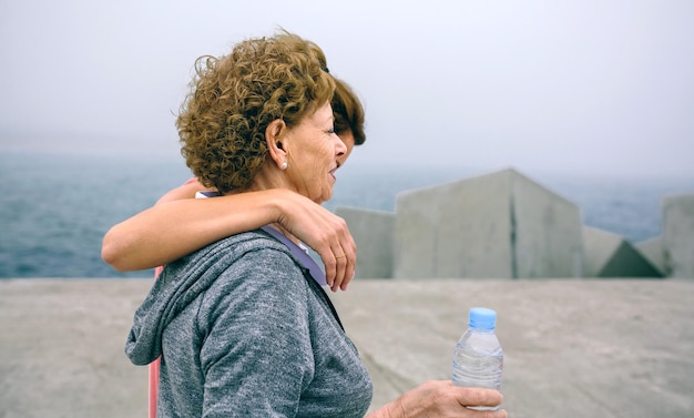 Photo mother and daughter standing on pier against sky