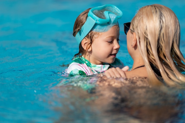 Mother and a daughter swimming in the pool