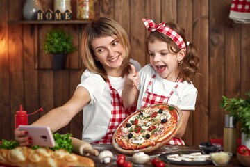 Premium Photo | Mother and daughter taking selfie with pizza on smartphone