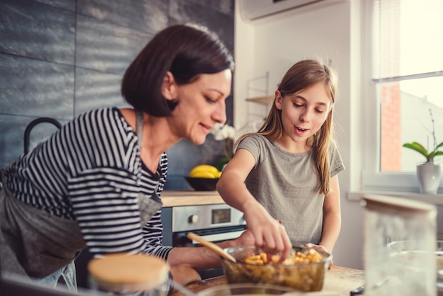 Mother and daughter tasting apple pie filling