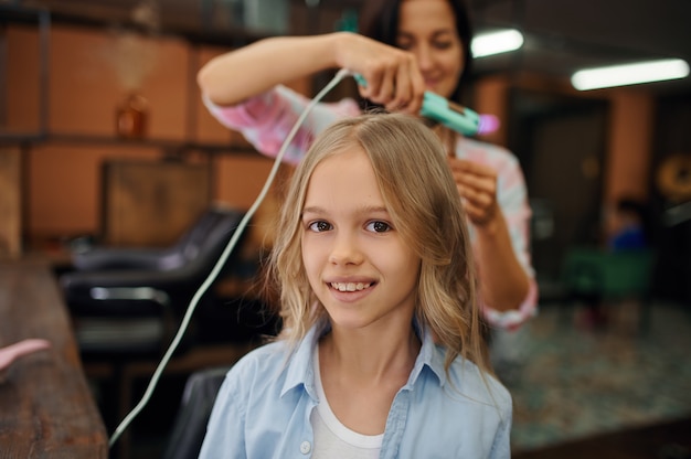 Mother and daughter do their hairstyles in hair salon