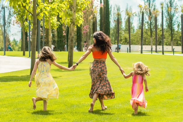 Mother and daughter together walking barefoot in the park