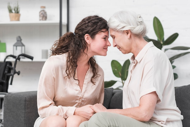 Mother and daughter touching heads together holding each other's hand