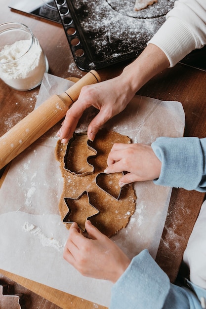 Foto madre e figlia che utilizzano forme di biscotti a casa