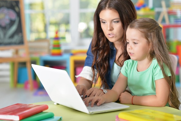 Mother and daughter using laptop