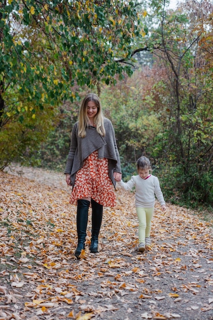 Photo mother and daughter walking in autumn park