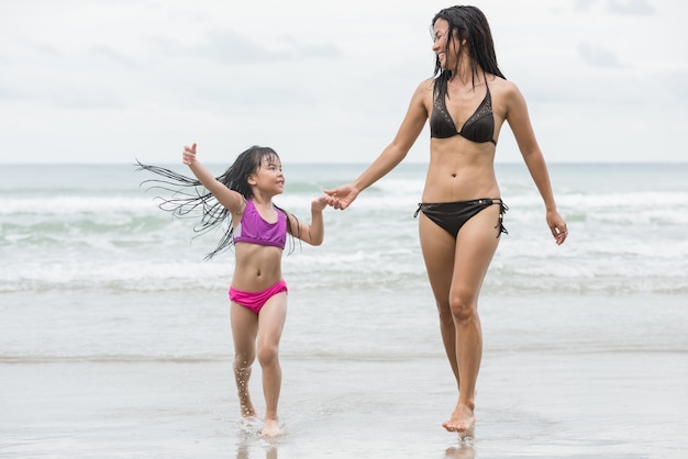 Mother and daughter walking on the beach.