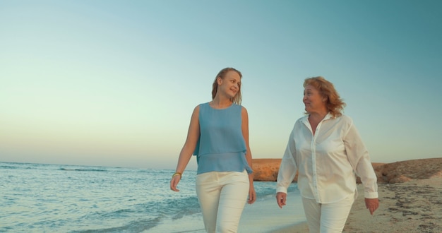 mother and daughter walking by the sea