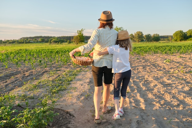 Mother and daughter walking with a basket of fresh eggs