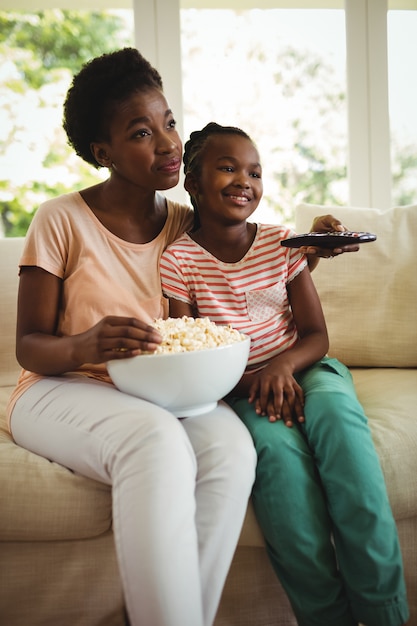 母と娘のリビングルームでテレビを見て