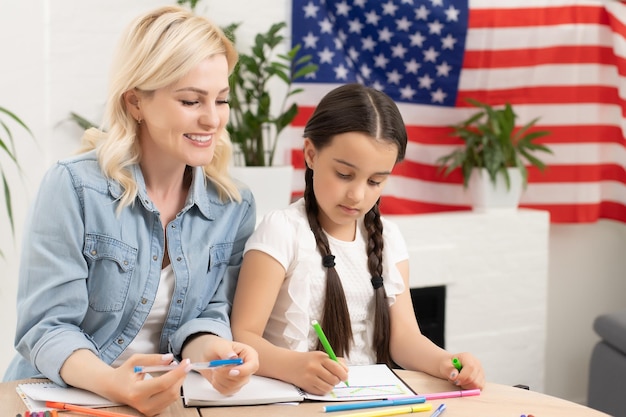 アメリカの国旗を持つ母と娘。