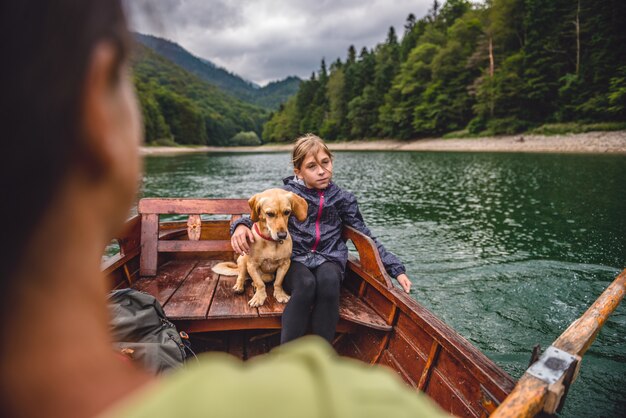 Mother and daughter with a dog rowing a boat