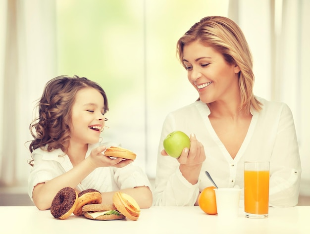 mother and daughter with healthy and unhealthy food