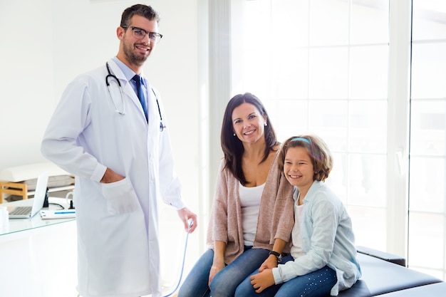 Foto madre e figlia con medico maschio che guarda l'obbiettivo in ufficio.