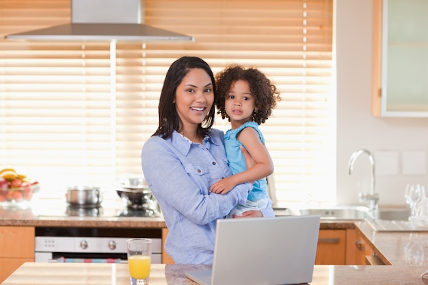 Mother and daughter with notebook in the kitchen together